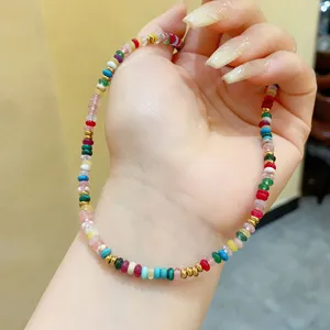 Hand-held detail of Bohemian colorful stone beaded necklace with elegant gold accents