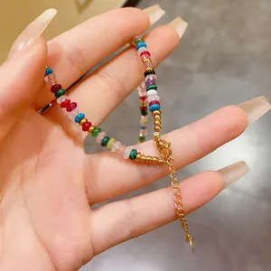 Close-up detail of bohemian multi-colored stone necklace with gold-tone clasp and chain