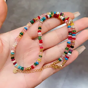 Macro view of bohemian colorful stone necklace with golden heart charm and S.Steel tag