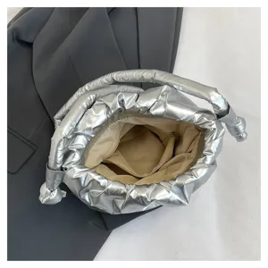 Detail view of the silver metallic puffer bucket bag showing interior lining and zipper pocket.