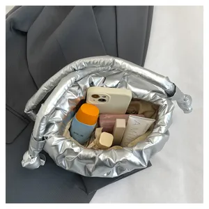 Silver quilted puffer bucket bag detail showing spacious interior capacity and metallic finish.