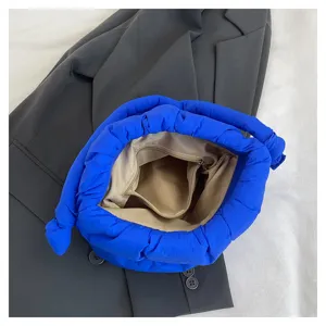 Interior detail view of the blue quilted nylon bucket bag showing lining and zipper pocket.