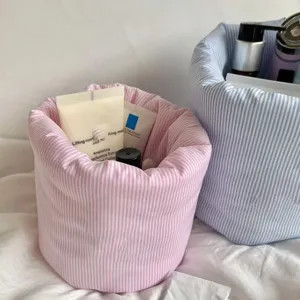 Gros plan sur le panier de rangement en tissu quilté, organiseur de maquillage rayé.