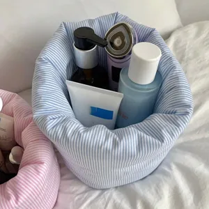 Panier de rangement cosmétique en tissu détail, organisateur maquillage rond rayé bleu.