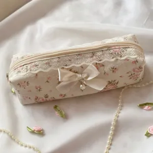 Gros plan détaillé de la trousse à crayons florale avec une bordure en dentelle.