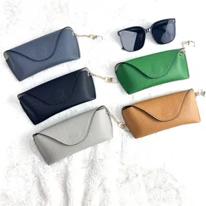 Minimalist leather glasses case detail view, portable sunglasses storage with chain and flap.