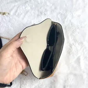 Detailed shot of portable leather glasses storage case with chain and sunglasses inside.