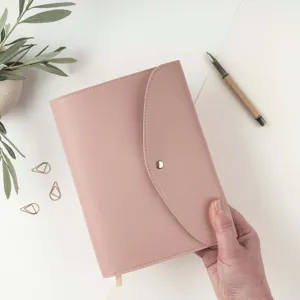 Detail view of the pink PU leather 3-fold A5 notebook folder with snap button closure.