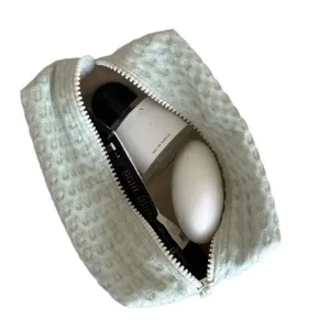 Interieurdetail van groene wafel gewatteerde make-up tas, draagbare reistas voor cosmetica.
