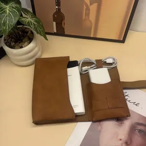 Gedetailleerd overzicht van de bruine lederen opbergtas voor digitale accessoires en kabels.