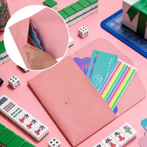 Dettaglio in primo piano del porta carte da mahjong in pelle rosa con slot e bottone.