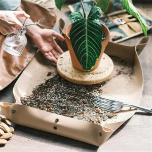 Waterproof leather gardening mat for repotting plants, thick folding dirt tray for indoor plant care.