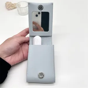 Vista dettagliata della custodia in pelle grigia per rossetto con specchio, organizer.