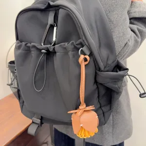 Sac à dos casual noir avec charm de fleur en cuir marron élégant pour un usage quotidien.