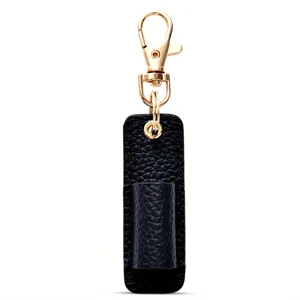 Detalle portalápices de cuero negro, mosquetón portátil, accesorio de oficina compacto.