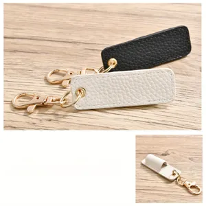 Juego de llavero portalápices de cuero portátil en negro y blanco con herrajes dorados.