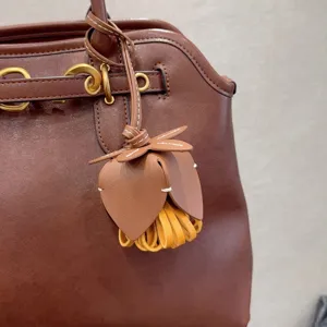 Détail de breloque de sac en cuir marron, ornement suspendu chic avec glands pour sacs.