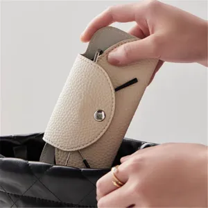 Gros plan détail de l'étui à lunettes en cuir beige, pochette de lunettes de soleil scène.
