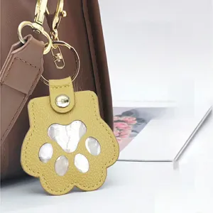 Pet hair memorial keychain paw pendant detail view, cute leather accessory for keys and bags.