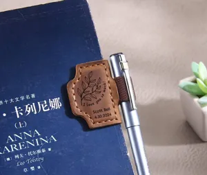 Vue détaillée d'un marque-page magnétique en cuir vintage avec porte-stylo sur un livre.