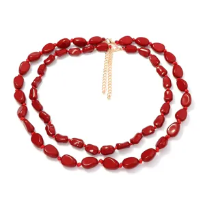Dettaglio della elegante collana di perle rosse ovali e irregolari a doppio strato per donna.