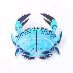 Close-up of the stylish blue crab acrylic brooch detail, showing vibrant shell patterns.