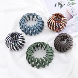 Detailed close-up showing various colors of expandable birds nest hair clips on clean white cloth.