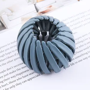 Detailed shot of a grey bird nest hair clip, showing its unique expandable design features.