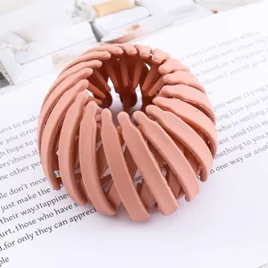 Pink expandable bird nest hair clip detail showing flexible mesh ring structure for ponytails.