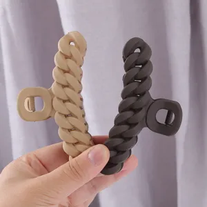 Detailed view of matte acrylic chain hair claw clips in beige and dark brown colors.