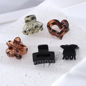 Detailed view of assorted small hair claw clips featuring flower, heart and rectangle shapes.