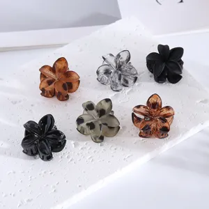 Detail view of multi-color mini flower hair claw clips, perfect for styling bangs and side hair.