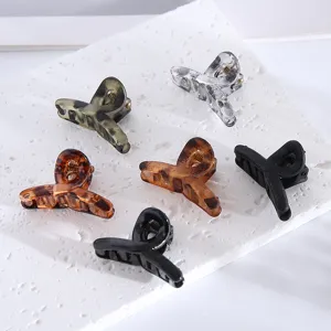Detail shot of small hair claw clips in assorted colors and patterns, perfect for styling bangs.