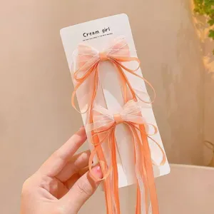 Cute children mesh bow hair clips with long streamers, bright orange color, perfect detail.