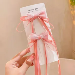 Cute pink mesh bow hair clips with long ribbons detail shot, perfect for children styling accessories.