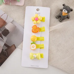 Close-up detail of cute yellow cartoon hair clips set on card, sweet style accessories.