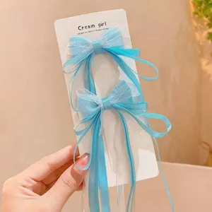 Detailed view of blue mesh bow hair clip with long ribbons, perfect for cute styling.