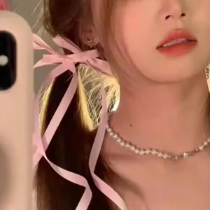 Pink bow ribbon hair clip detail closeup, cute sweet style hair accessory for women.