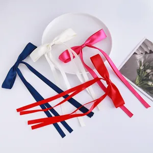Satin ribbon bow hair clip detail showing multiple colors and long streamers for sweet styling.