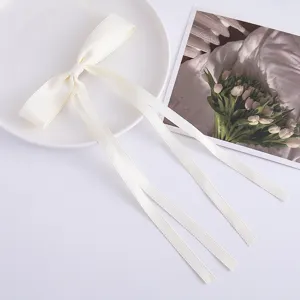 Detailed close-up view of the white satin ribbon bow hair clip, sweet girl style hair accessory