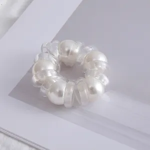 Primo piano del fermacapelli minimalista di perle in filo telefonico, design a spirale trasparente.