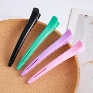 Detailed close-up of professional hairdressing long beak hair clips in various colors.