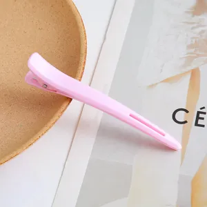 Professional pink hairdressing duckbill clip for sectioning and styling hair securely.