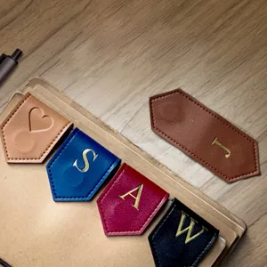 Close-up of colorful leather magnetic bookmarks with gold foil letters placed on a notebook.