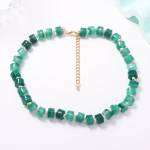 Collana di perle cilindriche verdi con catena di estensione dorata, stile estivo.