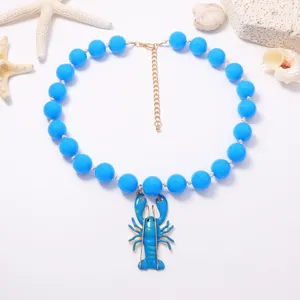 Gros plan détail du collier de perles bleues avec pendentif homard mignon pour l'été.