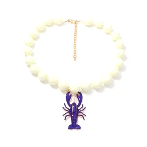 Collier statement de perles blanches chic avec pendentif homard bleu pour l'été.