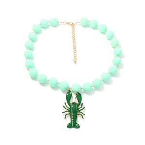 Vue détaillée du collier de perles vert menthe avec un pendentif homard vert unique.