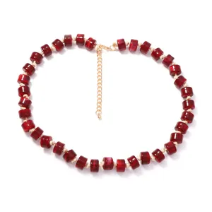 Dettaglio collana con perline rosse, elegante accessorio di gioielleria estiva con catenina