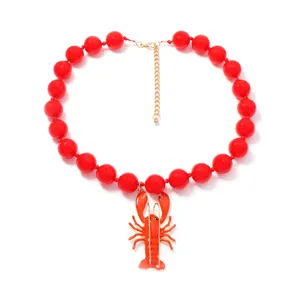 Collier pendentif homard perles rouges gros plan, mode vacances été plage accessoire de bijoux.